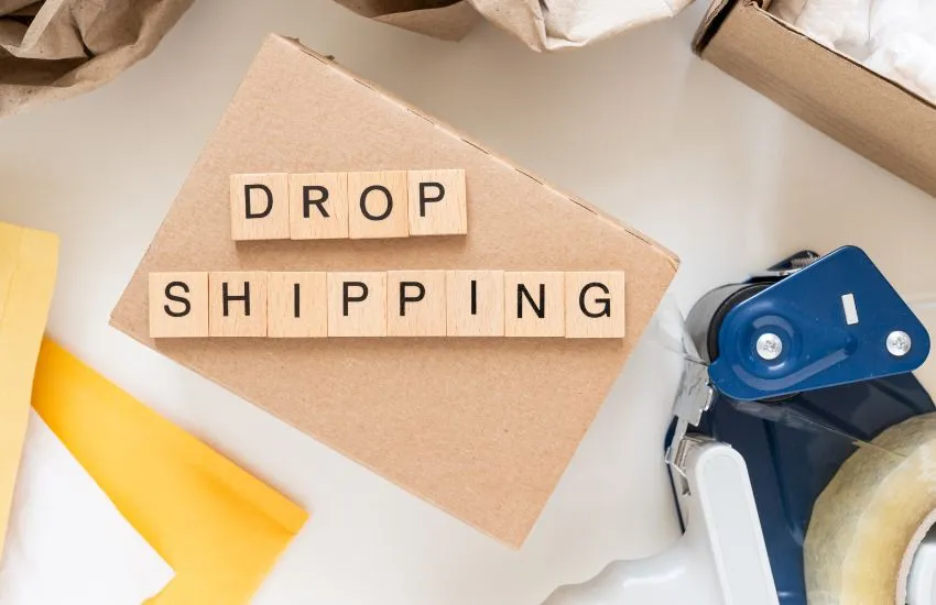 Το λεκτικό DROP SHIPPING και δίπλα του αναλώσιμα υλικά (χαρτικά, σελοτέιπ).